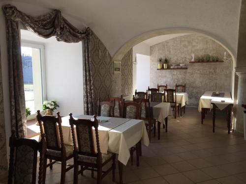 KrnskoHotel Dvůr的餐厅设有桌椅和大窗户。