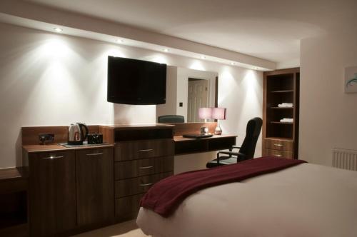 翰索哈维里酒店的酒店客房配有一张床和一张书桌及一台电视