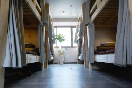长崎卡萨野田青年旅馆的走廊上的房间设有三张床