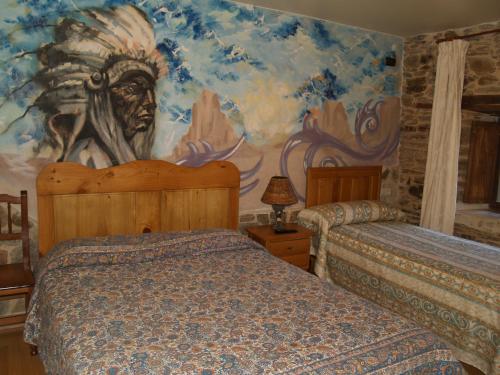 普韦布拉桑纳比亚部落旅馆的一间卧室配有两张床和壁画