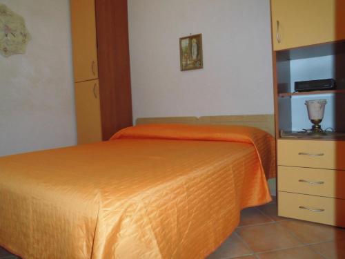 卡斯泰拉马莱Villa bellavista的一间卧室配有橙色的床和梳妆台