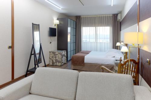维戈Oca Ipanema Hotel的酒店客房,配有床和沙发