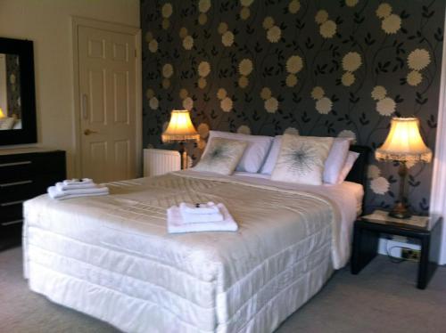 卡林福德Carlingford House Town House Accommodation A91 TY06的一间卧室配有一张带两盏灯的大型白色床。