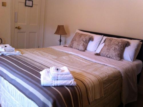 卡林福德Carlingford House Town House Accommodation A91 TY06的一间卧室配有一张大床和毛巾