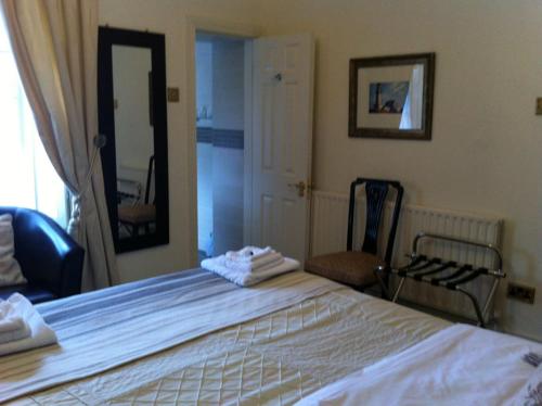 卡林福德Carlingford House Town House Accommodation A91 TY06的卧室配有一张白色大床和镜子