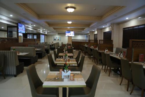 KhammamHotel Grand Gayathri的餐厅内带桌椅的用餐室