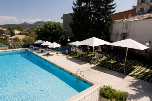 特伦普二十世纪酒店的一个带遮阳伞和桌椅的游泳池