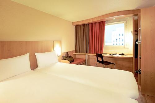 博韦宜必思博韦机场酒店的卧室配有一张白色大床和一张书桌