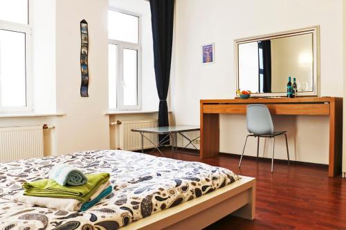 圣彼得堡拉卡萨帝贝利1号公寓式酒店的一间卧室配有一张床、一张桌子和一把椅子