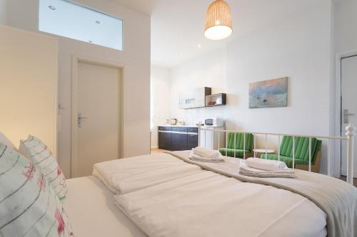 柏林Stylish & Cosy Apartment in Berlin, WiFi的卧室配有一张带绿椅的大型白色床