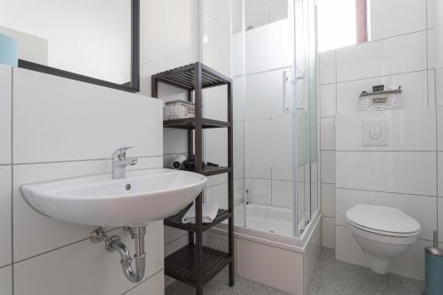 柏林Stylish & Cosy Apartment in Berlin, WiFi的白色的浴室设有水槽和卫生间。