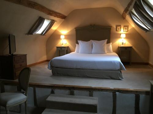 ChamantHotel L'Aunette Cottage的一间卧室配有一张带两盏灯和一把椅子的床。