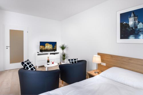 布拉格城西公寓的一间卧室配有一张床和一张带椅子的桌子