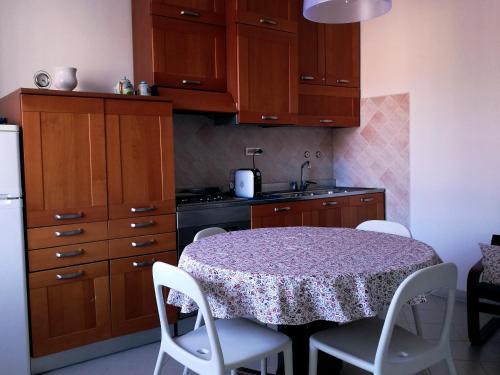 东塞斯特里La Piazzetta的厨房配有带白色椅子的桌子和水槽