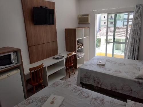 伊塔佩马波萨达泰拉索尔旅馆的小房间设有一张床和一张桌子及椅子
