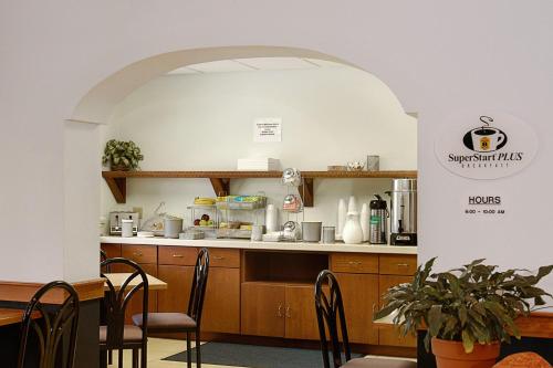 曼切斯特曼彻斯特机场速8酒店的餐厅内的厨房配有桌椅