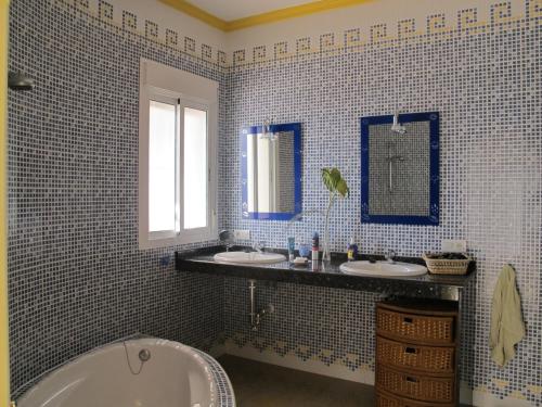 阿里纳斯Villa Camakini的蓝色瓷砖浴室设有2个水槽和1个浴缸