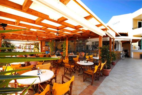 卡拉马孔凡妮莎酒店 的一个带桌椅的户外庭院和一间餐厅