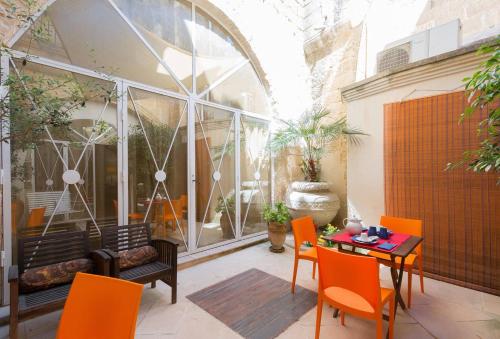 莱切科尔特代麦莫里酒店的庭院配有橙色椅子和桌子