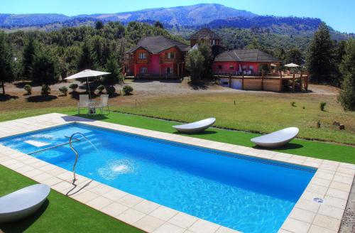 佩休尼亚镇蒙塔尼亚康普莱约普埃尔托曼伦俱乐部宾馆的一座房子,设有一座带两把白色椅子的大型游泳池