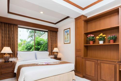 南芭堤雅莱西登斯花园酒店的一间卧室设有一张大床和一个窗户。