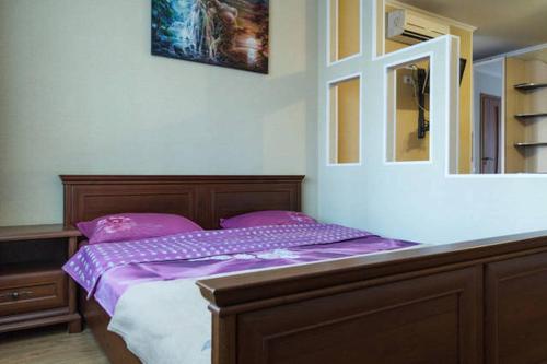 尼古拉耶夫Затишна квартира у самому центрі , на Соборній的一间卧室配有一张带紫色床单的床和窗户。