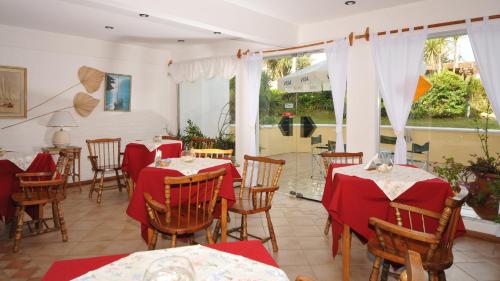 埃斯特角城Bagu Villa de Mar的餐厅配有桌椅和红色桌布