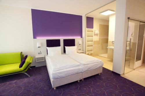格拉尔-米里茨瓦德博丽酒店的卧室配有白色的床和绿色椅子