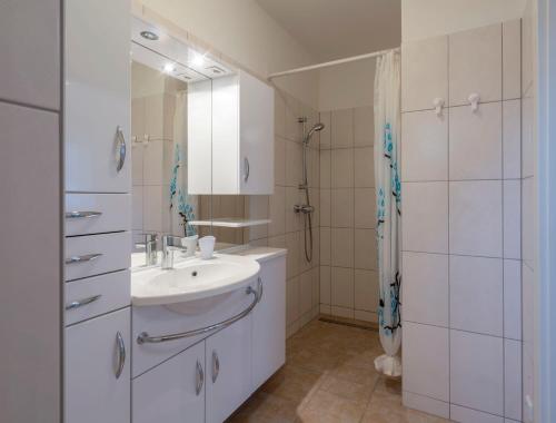 维也纳新城WN客房旅馆的白色的浴室设有水槽和淋浴。