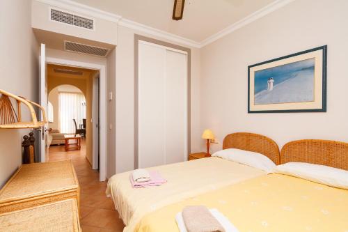 内尔哈Carabeo 52 Apartments Casasol的一间卧室配有两张床、一张桌子和一把椅子