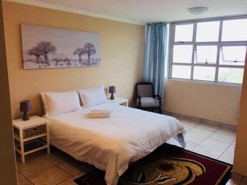 阿曼济姆托蒂Strandburg Holiday Apartments的卧室配有白色的床和窗户。