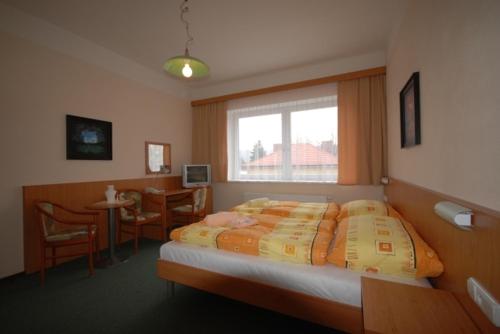 洪波莱茨鲁斯旅馆的一间卧室配有一张床、一张桌子和一个窗户。