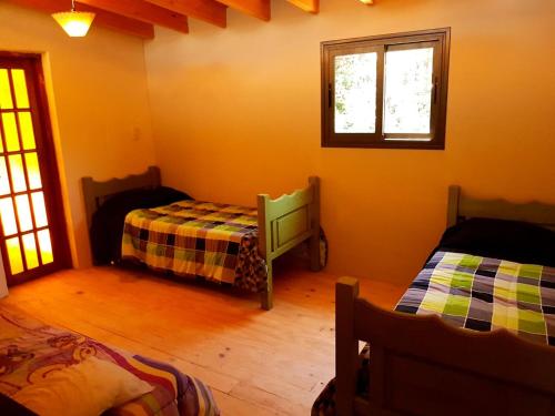 图努扬Mágico Atardecer Cabaña的一间卧室设有两张床和窗户。
