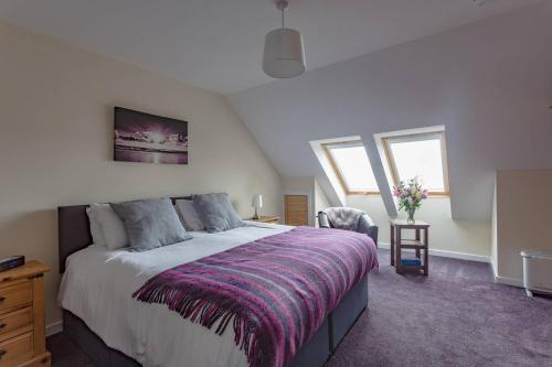 BorveArdenlee Self Catering Apartment的一间卧室配有一张大床和紫色毯子