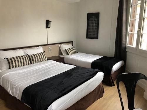 鲁昂雷伊尼蒂耶酒店的酒店客房设有两张床和窗户。