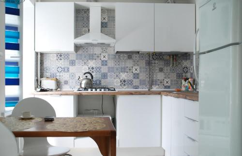 切尔尼戈夫Бело-голубая безмятежность的厨房配有白色橱柜和木桌