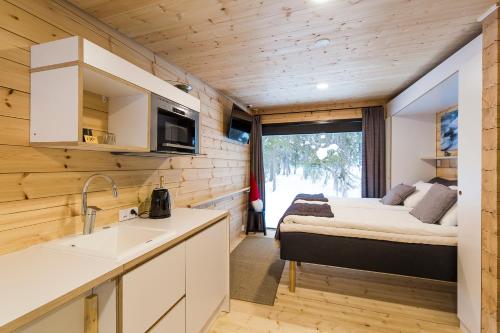 RovaniemiVaattunki Wilderness Resort的一间厨房和客厅,位于一个小房子里