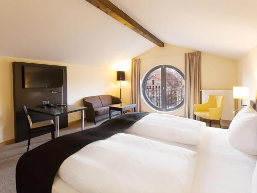 吕讷堡多美洛老百货酒店的一间设有大床和窗户的酒店客房