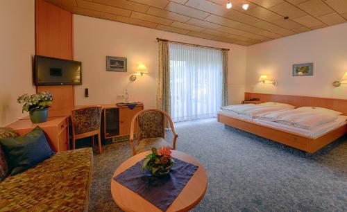 Jübek古斯酒店的酒店客房设有床和客厅。