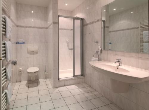 Jübek古斯酒店的一间带水槽、淋浴和卫生间的浴室
