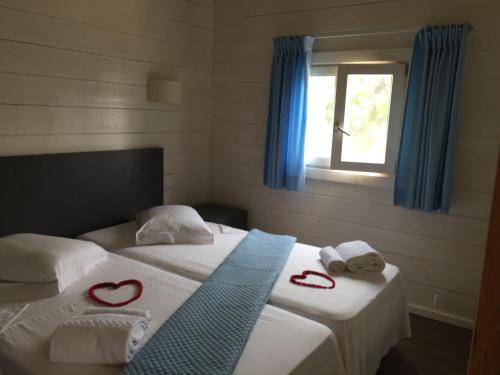 Porto AlegreN`Guembú Nature Resort的一间卧室配有两张床、红毛巾和窗户。