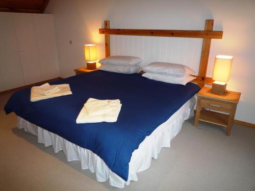 瓦特维尔Waterville Holiday Homes No 1的一间卧室配有蓝色的床和毛巾