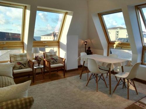 圣西普里安San Ciprian Atico Playa by I Love Norte的客厅配有桌椅和窗户。