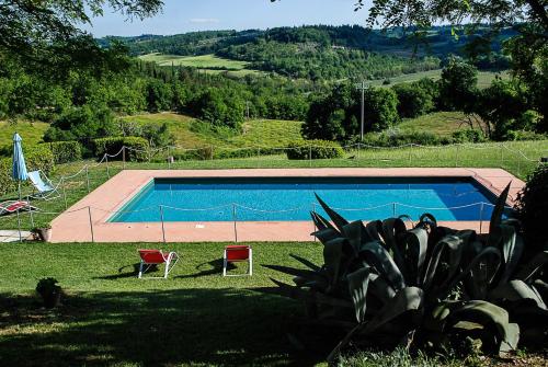 瓦尔的圣卡西亚诺吉内斯特拉生态农家乐的一个带两把椅子的庭院内的游泳池