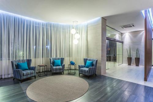 巴乌鲁蓝树塔包鲁酒店的大堂设有蓝色椅子和圆形地毯