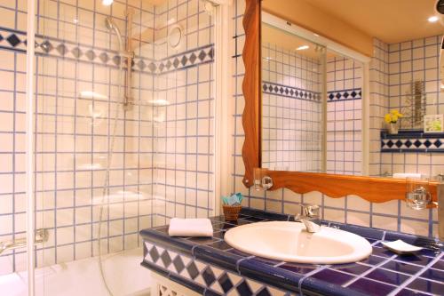 圣洛朗－德塞尔当法尔格地区高尔夫及spa酒店的一间带水槽、浴缸和镜子的浴室