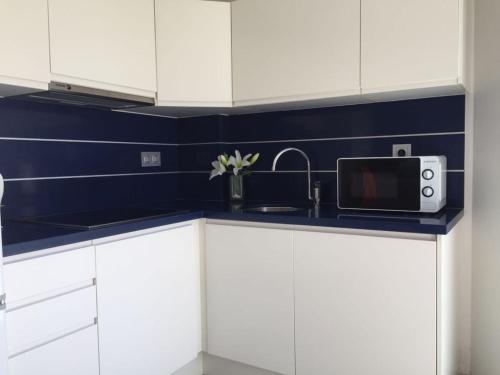 瓜尔达马尔·德尔·塞古拉Apartamentos Marjal 3的厨房配有白色橱柜、水槽和微波炉