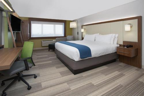 达拉斯Holiday Inn Express & Suites Dallas NE Arboretum的酒店客房配有一张床、一张书桌和一台电脑