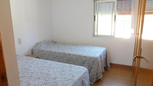 塔韦尔内斯德拉瓦利迪格纳Chalet Verde的小房间设有两张床和窗户