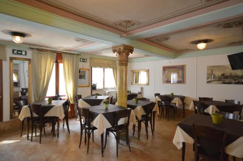 威尼斯阿尔伯格玛林酒店的用餐室配有黑色的桌椅